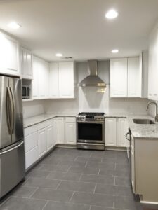 White kitchen with grey tile floors.